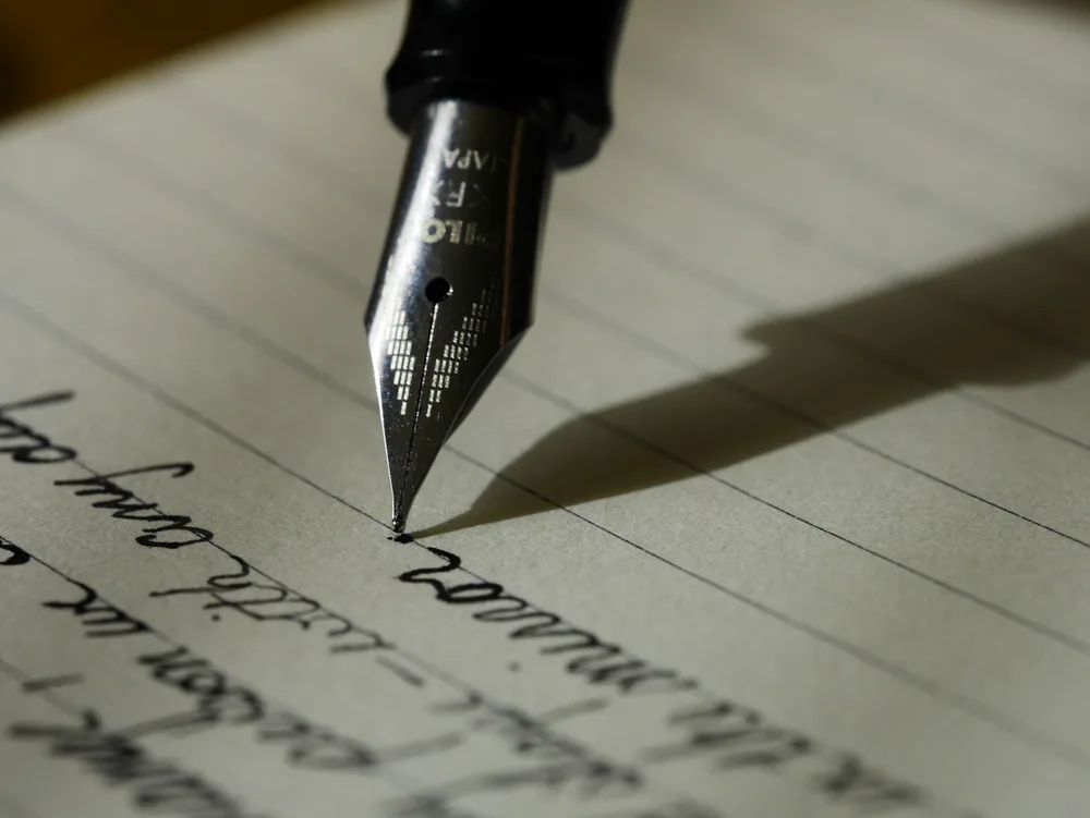 A learner writing notes in a notebook